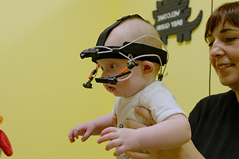 一个婴儿戴着头戴式摄像头，以收集她的视角的视觉数据.